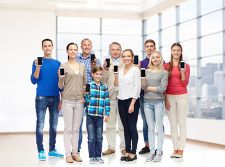 group of smiling people with smartphones
