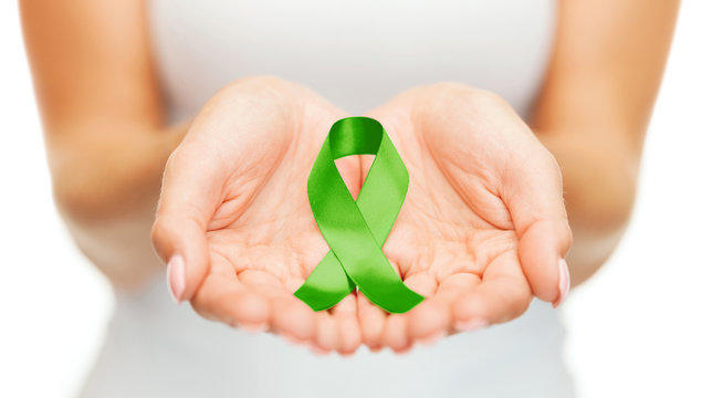 hands holding green awareness ribbon