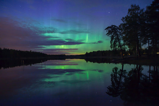 Northern lights over calm lake in Sweden (Aurora borealis) © Conny Sjostrom