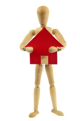 Homme en bois avec une maison en papier rouge dans les bras