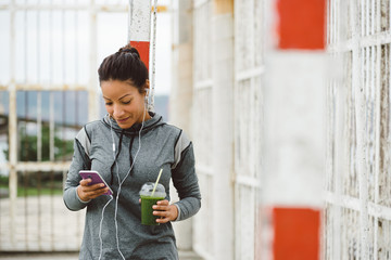 Urban fitness woman texting on her smarphone - 96245653