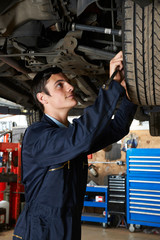 Trainee Mechanic Working Under Car