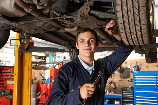 Apprentice Mechanic Working On Car