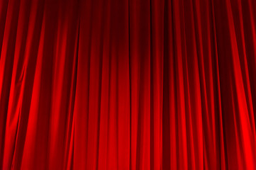 Rideau fermé rouge avec des taches lumineuses dans un théâtre