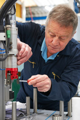 Engineer Working On Machine In Factory