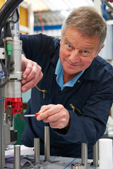 Engineer Working On Machine In Factory