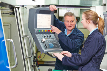 Engineer Showing Apprentice How to Use Computerized Cutting Mach