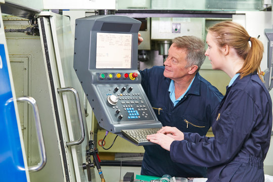 Engineer And Apprentice Using Computerized Cutting Machine