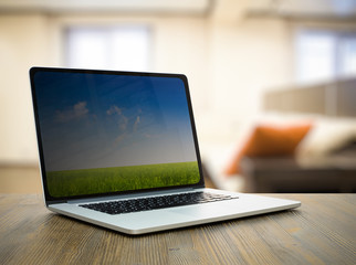 computer on wooden table in room