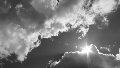 Fototapety  na niebie słońce przebija się przez chmury. Czarno-białe zdjęcie