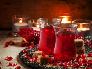 Festive red hot drink with pomegranate on an old wooden table ag