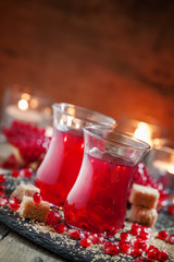 Festive red hot drink with pomegranate on an old wooden table ag