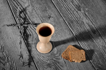 Chalice and bread on the wooden table