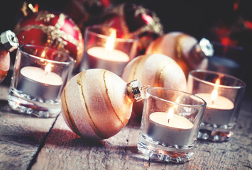 Christmas balls, burning candles on the old wooden background, d