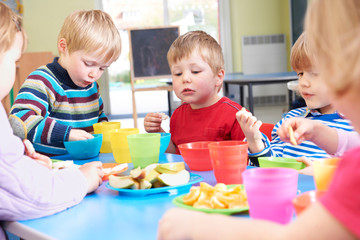 Pre School Children Eating Healthy Snacks At Breaktime