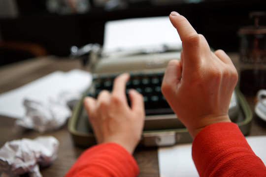 woman typing on old typewriter