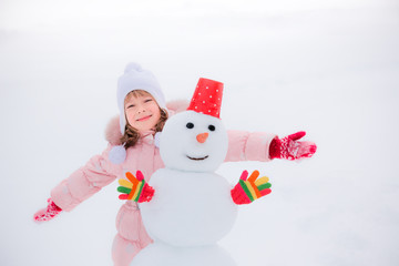 Child and snowman in winter
