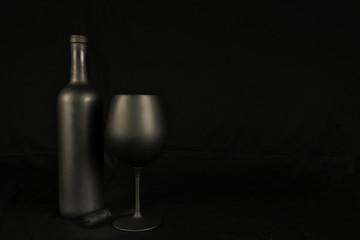 Flat Black Wine Bottle, Wine Glass on black background