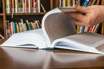 The hand opening and browsing the book pages
