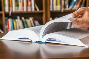 The hand opening and browsing the book pages