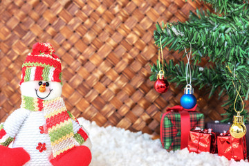 snowman and christmas tree with the snow in wicker background