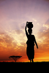 African woman silhouette at sunset - obrazy, fototapety, plakaty