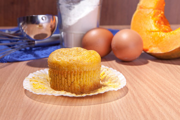 One cupcake, pumpkin and baking kitchenware on wood texture table