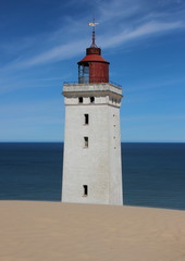 Fototapeta na wymiar Lighthouse with Sand Dune and Blue Ocean in Horizon