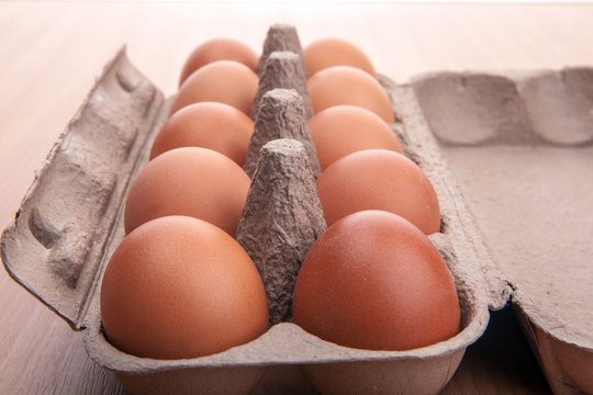 brown eggs in egg carton on kitchen table