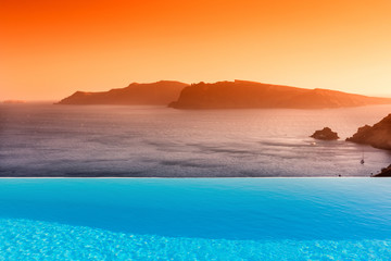 Fototapeta na wymiar Infinity pool on the rooftop with the ocean in Santorini Island,