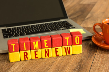 Time to Renew written on a wooden cube in a office desk