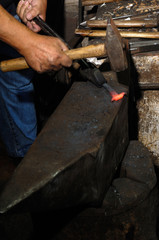 Blacksmith forges iron in the forge