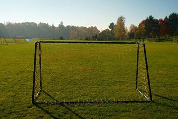 Old Football Gate On Village  Football Field. Sunny day at the end of season, poor grass