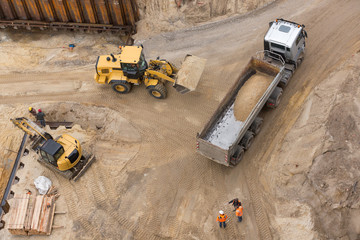 Radlader fährt Sand zu Kipplaster © Kara