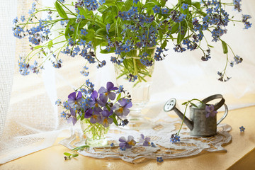 Forget-me-nots and pansies flowers in a vase