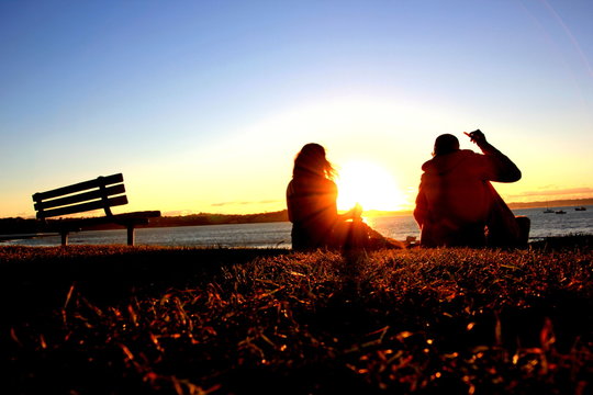 P&auml;rchen sieht sich einen Sonnenuntergang am Meer an