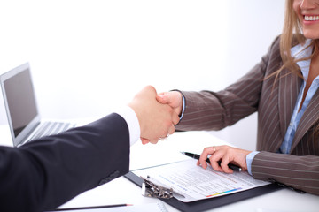 Obraz premium business handshak sitting at the desk on office background, copy space area at the left upper corner