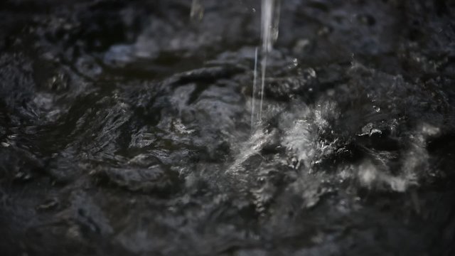 Rain water pouring in black basin