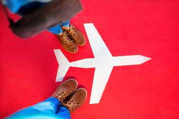 Airplane sign with couple's legs on the red background