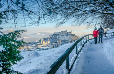 Fototapeta premium Beautiful view of Salzburg with snowy path and Fortress Hohensalzburg in winter, Austria