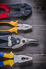 Collection of tin snips steel cutter pliers on wooden board