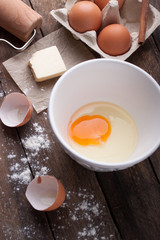 Ingredients and tools ready to make a cake, flour, eggs, butter, cinnamon stick on a wooden table. Selective focus.