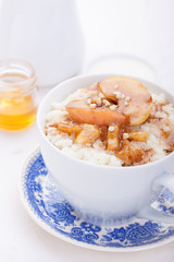Rice pudding with caramelized apples and honey in a white ceramic cup
