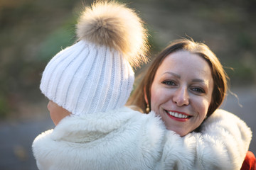 Happy mother with daughter in hands