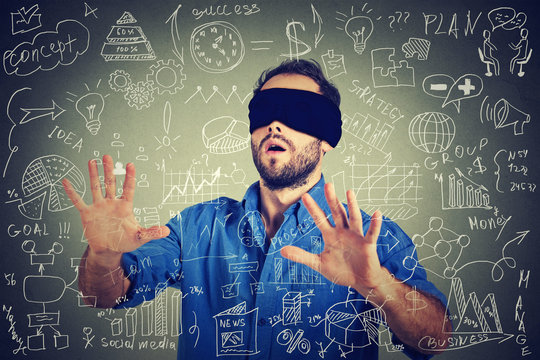Blindfolded young business man searching walking through social media financial data plan