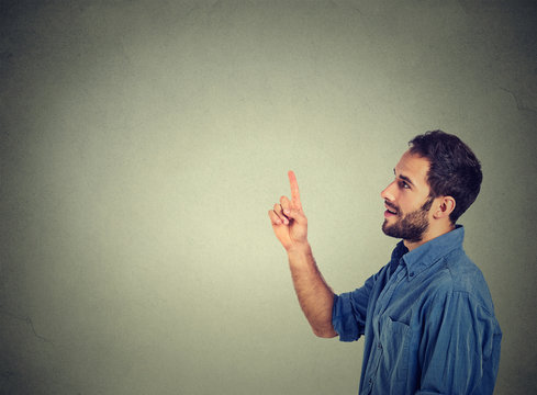 Happy young man pointing looking at copy space