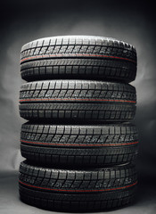 studless winter tires stack, black background © nikkytok