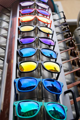 Skyscraper of bright unbranded plastic sunglasses for sale. Mirror style.