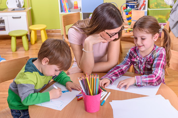 cute girl and boy with kindergarten teacher