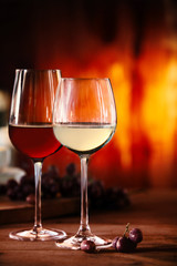 Red and white wine in front of a blazing fire